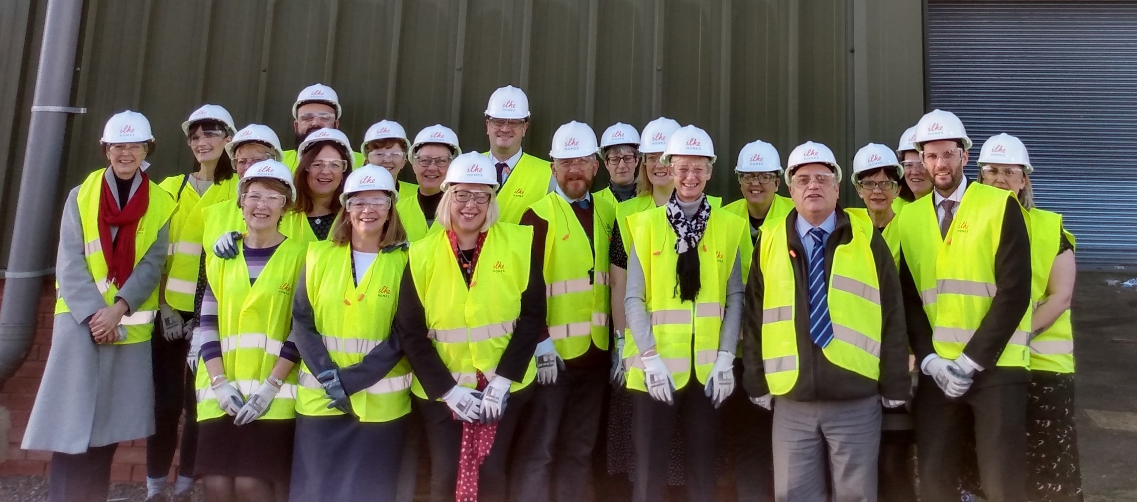 Delegation wearing hi-vis stood in front of Ilke homes industrial unit